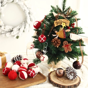 Red and white Christmas felt ball ornaments with miniature trees and pine cones