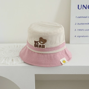 Detail of baby corduroy bucket hat featuring bear embroidery and soft textured fabric