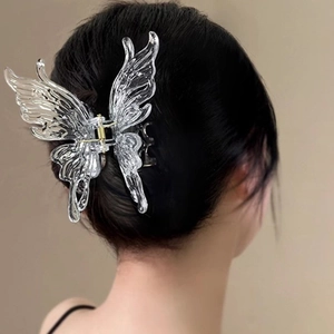 Vue détaillée d'une pince à cheveux papillon transparente sur de longs cheveux noirs