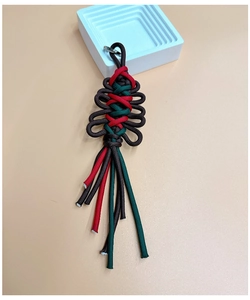 Macro shot of handmade Christmas woven keychain with red and green paracord knot textures