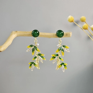 Detailed close-up of Chinese style bamboo leaf earrings with green enamel and crystals