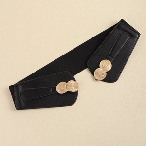 Women's black elastic waist belt with vintage gold metal buckle on beige background