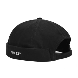 Bonnet docker en coton noir minimaliste avec broderie Low Key sur un fond blanc uni