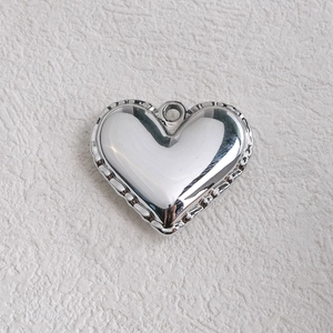 Detailed view of silver heart acrylic pendant with lace scalloped edges for DIY jewelry