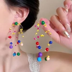 Detailed view of colorful beaded tassel earrings featuring vibrant beads on a model