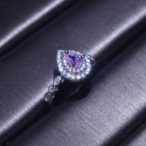 Luxurious silver-plated ring with a pear-cut purple gemstone surrounded by crystals