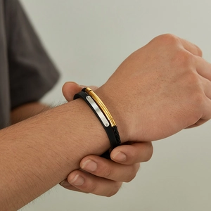 Gros plan d'un bracelet double couche en cuir tressé et barres métalliques pour homme