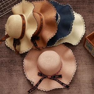 Summer wide brim straw sun hat with wavy edges and bow tie decoration in multiple colors