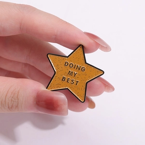Star-shaped enamel badge in yellow glitter with DOING MY BEST inspirational quote