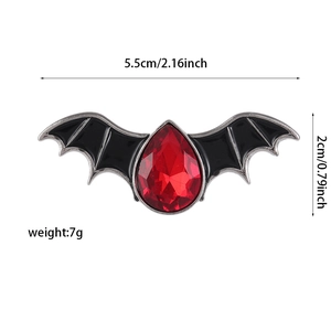 Detail view of devil bat brooch dimensions showing 5.5cm width with red crystal inlay