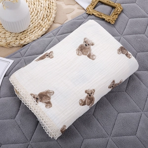 Detail of soft double-layer cotton baby gauze blanket with teddy bear prints and lace trim