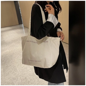 Minimalist beige canvas tote bag with DAUNTLESS lettering print and dual shoulder straps