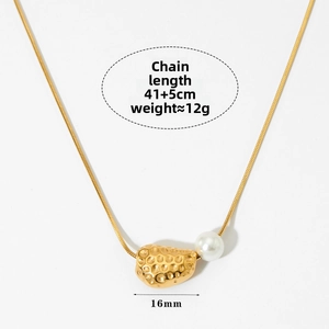 Detail of gold snake chain necklace featuring a hammered gold pendant and a white pearl