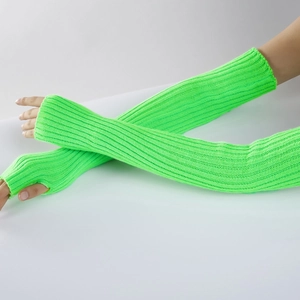 Detail view of neon green ribbed knit arm warmers with thumb holes on crossed arms
