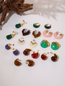 Detailed overhead view of colorful resin earrings with metallic textures and pearl accents