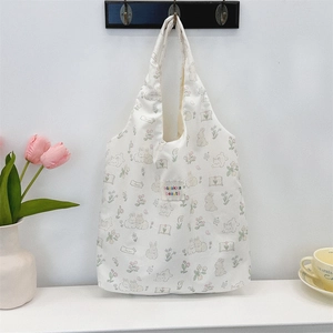 Détail de l'imprimé lapin mignon et de l'étiquette tissée sur un sac en toile crème
