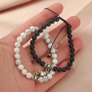 Naturstein-Armbänder mit Herz-Magnetverschluss für Paare auf Satinhintergrund