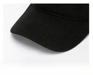 Detail of thickened black wool baseball cap brim with metallic hexagon logo badge