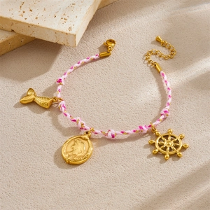 Bracelet nautique rose avec pendentif sirène doré et gouvernail sur pierre texturée