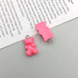 Detailed macro view of two pink resin gummy bear charms with metal loops for DIY crafts