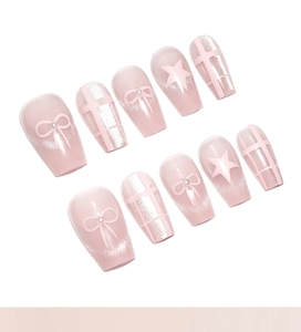 Detailed view of pink cat-eye press-on nails with 3D bow, pearls, and plaid pattern