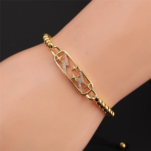 Bracciale a stella e fulmine placcato oro con zirconi indossato sul polso femminile
