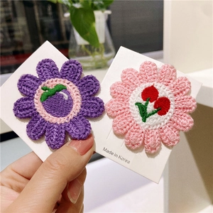 Handmade knitted sunflower hair clips in purple and pink with embroidery details