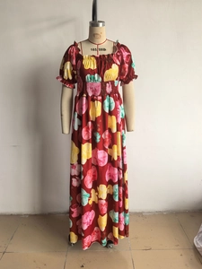 Détail de robe maxi fleurie rouge avec taille smockée et manches bouffantes sur mannequin
