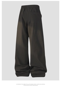 Detail of loose fit wide leg trousers featuring elastic waistband and rear patch pocket