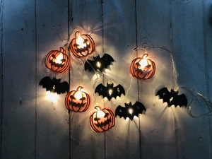 Detailed close-up of warm glowing LED Halloween lights with pumpkin and bat shapes
