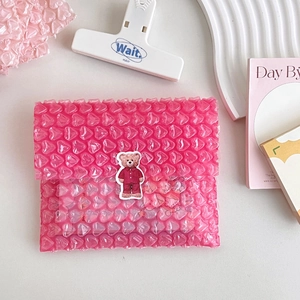 Pink heart-shaped bubble mailer featuring 3D bear sticker in a soft aesthetic setting