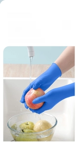 Blue nitrile cleaning gloves with non-slip texture washing fruit under running water