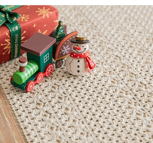 Close-up of cream handmade crochet table runner with hollow floral pattern and Christmas decor