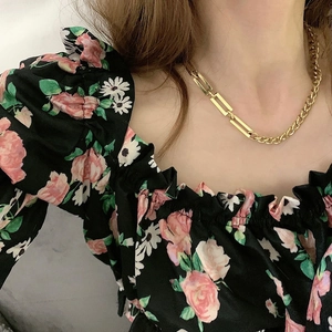 Close-up of golden Cuban link necklace with rectangular buckle on a model's neck