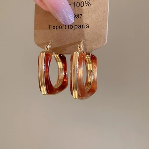 Close-up of vintage resin earrings with 18k gold plating on a kraft paper display