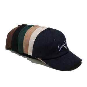Group display of multi-color corduroy baseball caps with bow embroidery detail