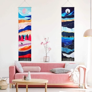 Detail of bohemian moon eclipse wall tapestries with tassels above a living room sofa