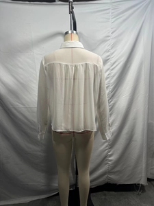 Vue arrière d'une chemise blanche en satin pour femmes avec plis et détails tressés