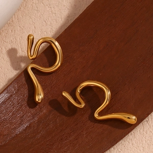 Detailed view of wavy 18K gold plated stainless steel earrings on a wooden base