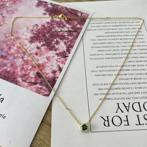 Detail of vintage gold necklace with round green zircon pendant and micro-pave crystals