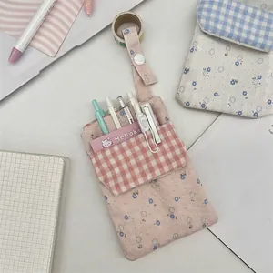 Pink floral canvas nurse pocket protector with flap for pens and tools in a desk setting