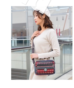 Ethnic style canvas shoulder bag with colorful stripes shown on a female model outdoors