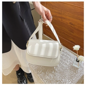 Detailed view of white leather shoulder bag featuring artistic window shadow lighting