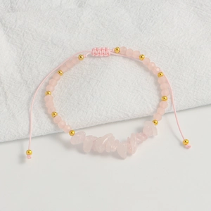 Close-up of pink quartz stone bracelet with adjustable braided rope and gold beads