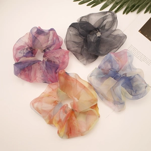 Close-up of four oversized organza scrunchies in gradient purple and blue on white background