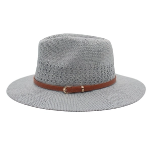 Detail of grey knitted panama hat showing the texture and brown leather strap with metal buckle