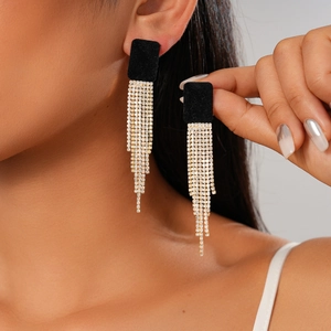 Boucles d'oreilles carrées en velours noir avec glands dorés en strass sur modèle
