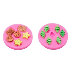 Pink silicone molds for crafting clay biscuits and Christmas trees on white background