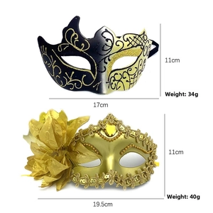 Detail view of black and gold masquerade masks with floral patterns and glitter finish