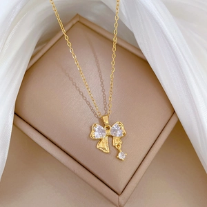 Close-up of golden bow pendant with clear cubic zirconia in a jewelry box